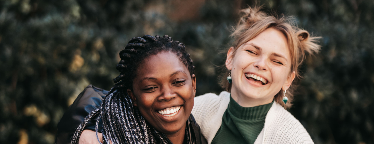 Dos chicas abrazadas y sonriendo a camara