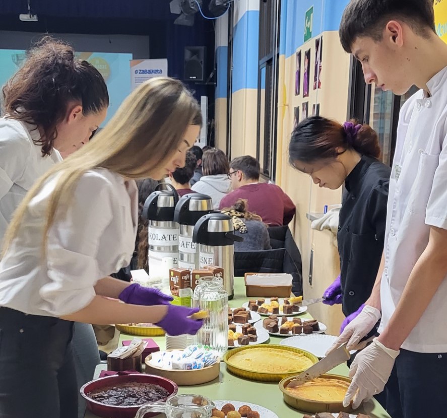 Grupo de cuatro chicos y chicas sirviendo diversos platos en una mesa