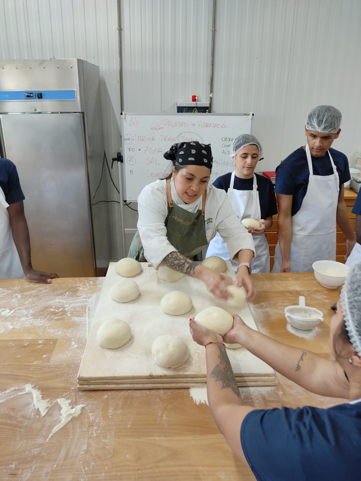 Un grupo de jóvenes en un obrador amasando pan