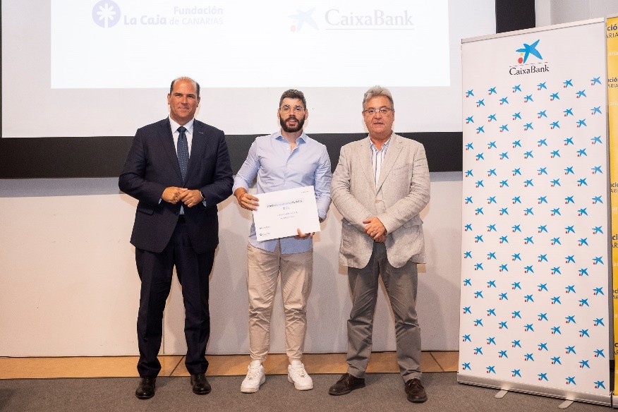 Tres personas en un escenario en una entrega de diplomas