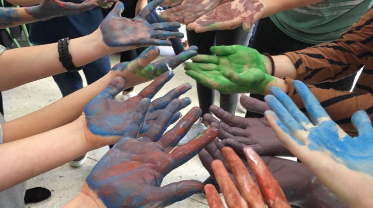 Las palmas de las manos de diferentes personas pintadas de distintos colores