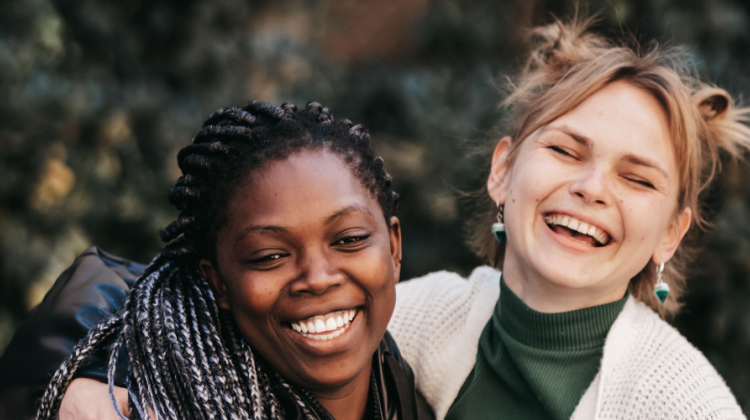 Dos chicas abrazadas y sonriendo a camara