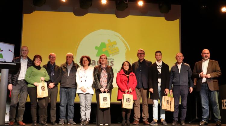 Un grupo de personas posando encima de un escenario. De fondo, el logotipo del 50 aniversario de Fundación Santa Lucía Adsis