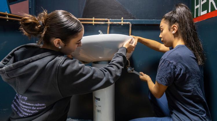 Dos chicas montando la pila de un baño