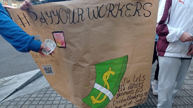 Pancarta en la que se lee "pay your workers"