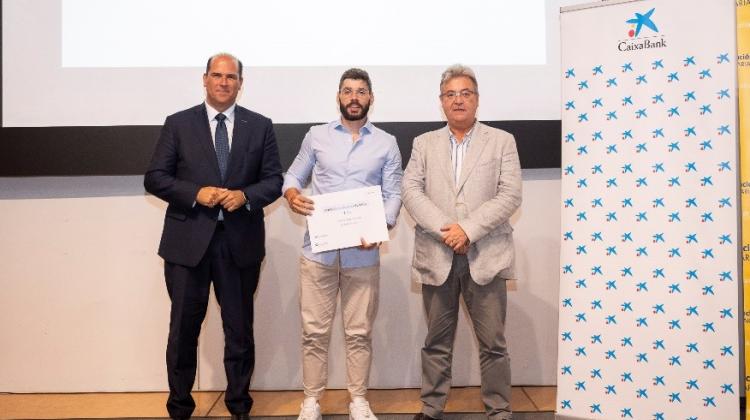 Tres personas en un escenario en una entrega de diplomas