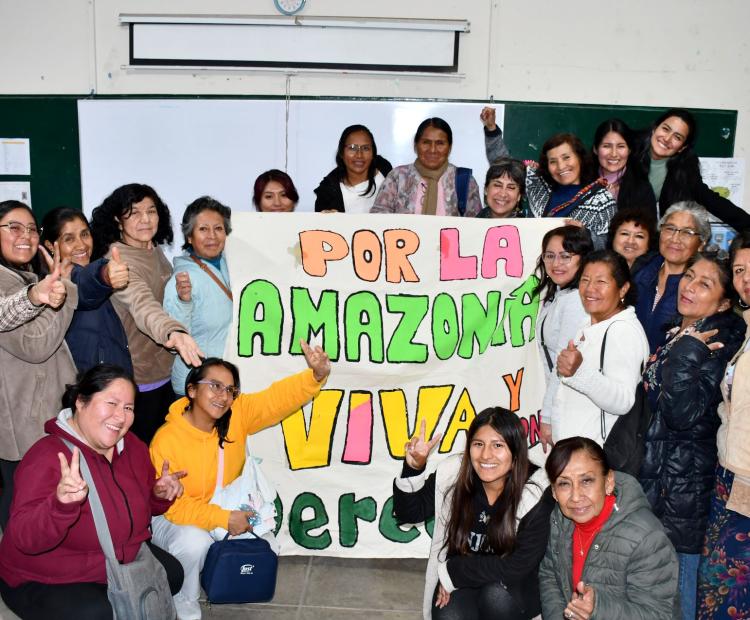 Un grupo de mujeres posando con una pancarta en la que se lee: Por la Amazonia viva y verde