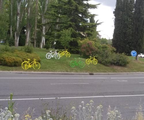 Diversas bicis de colores plantadas encima de una rotonda