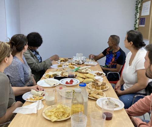 Un grupo de personas sentadas alrededor de una mesa compartiendo un desayuno
