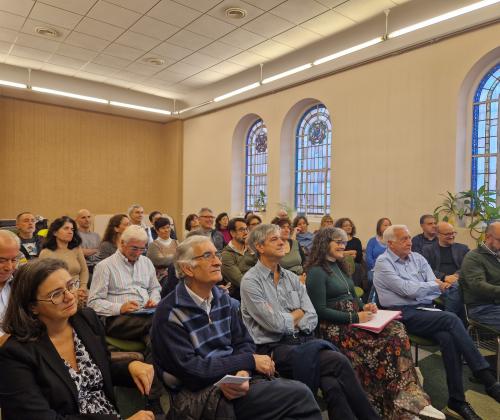 Público sentado en las sillas de una sala de actos