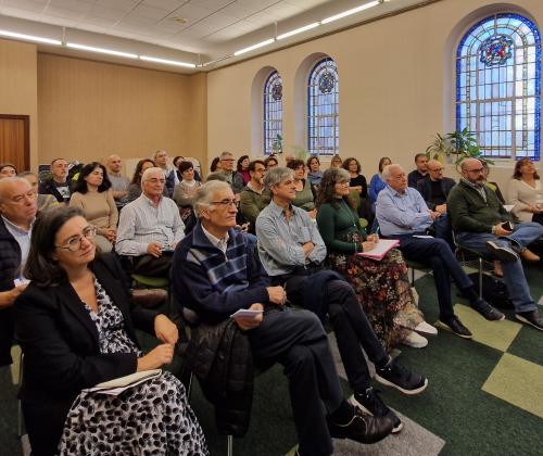 Público sentado en las sillas de una sala de actos