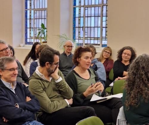 Público sentado en las sillas de una sala de actos