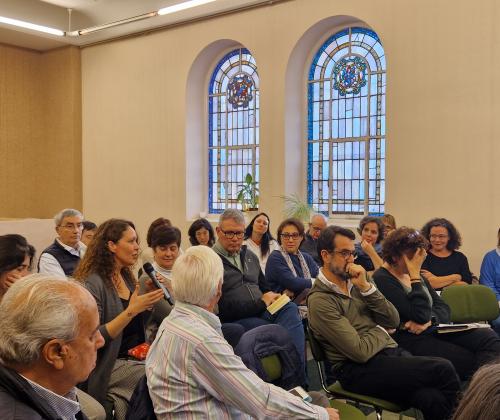 Público sentado en las sillas de una sala de actos