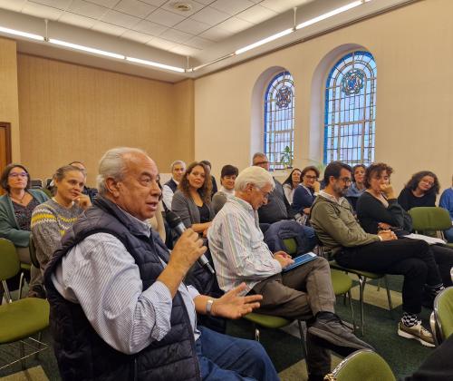 Público sentado en las sillas de una sala de actos